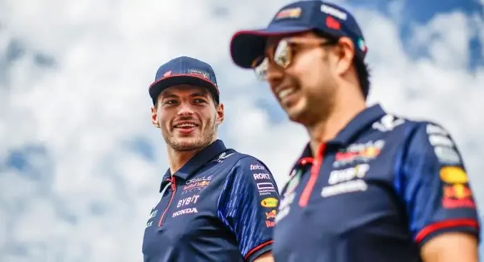 Red Bull drivers Max Verstappen and Sergio Perez share a joke at the 2023 Japanese Grand Prix.